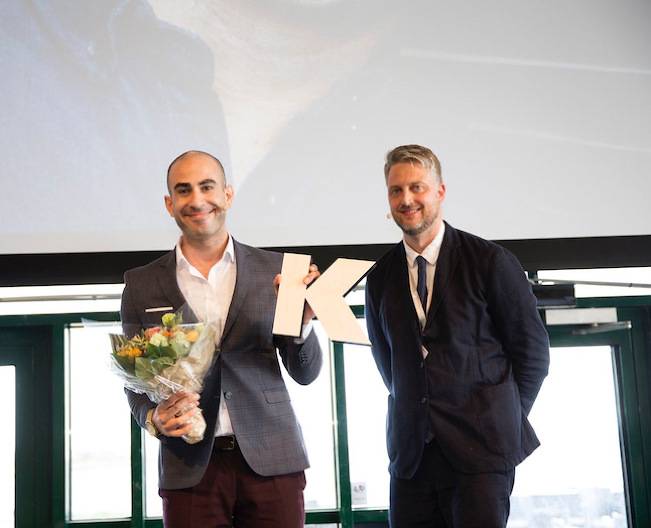 KOM18's store finale: Abdel Aziz Mahmud får DJ's og Kforums KOM-pris 2018. Kforums chefredaktør Timme Bisgaard Munk flankerer. Foto: Jeanne Kornum.
