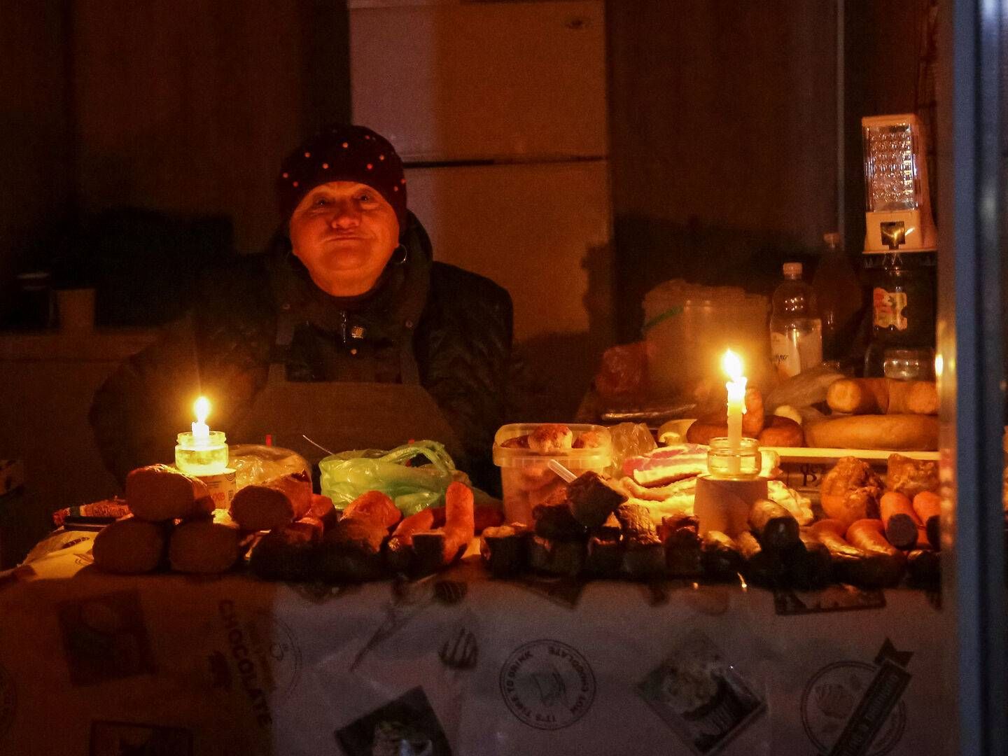 Indehaveren af en lille butik må bruge stearinlys under en strømafbrydelse i Odesa i begyndelsen af december 2022. | Foto: Stringer/Reuters/Ritzau Scanpix