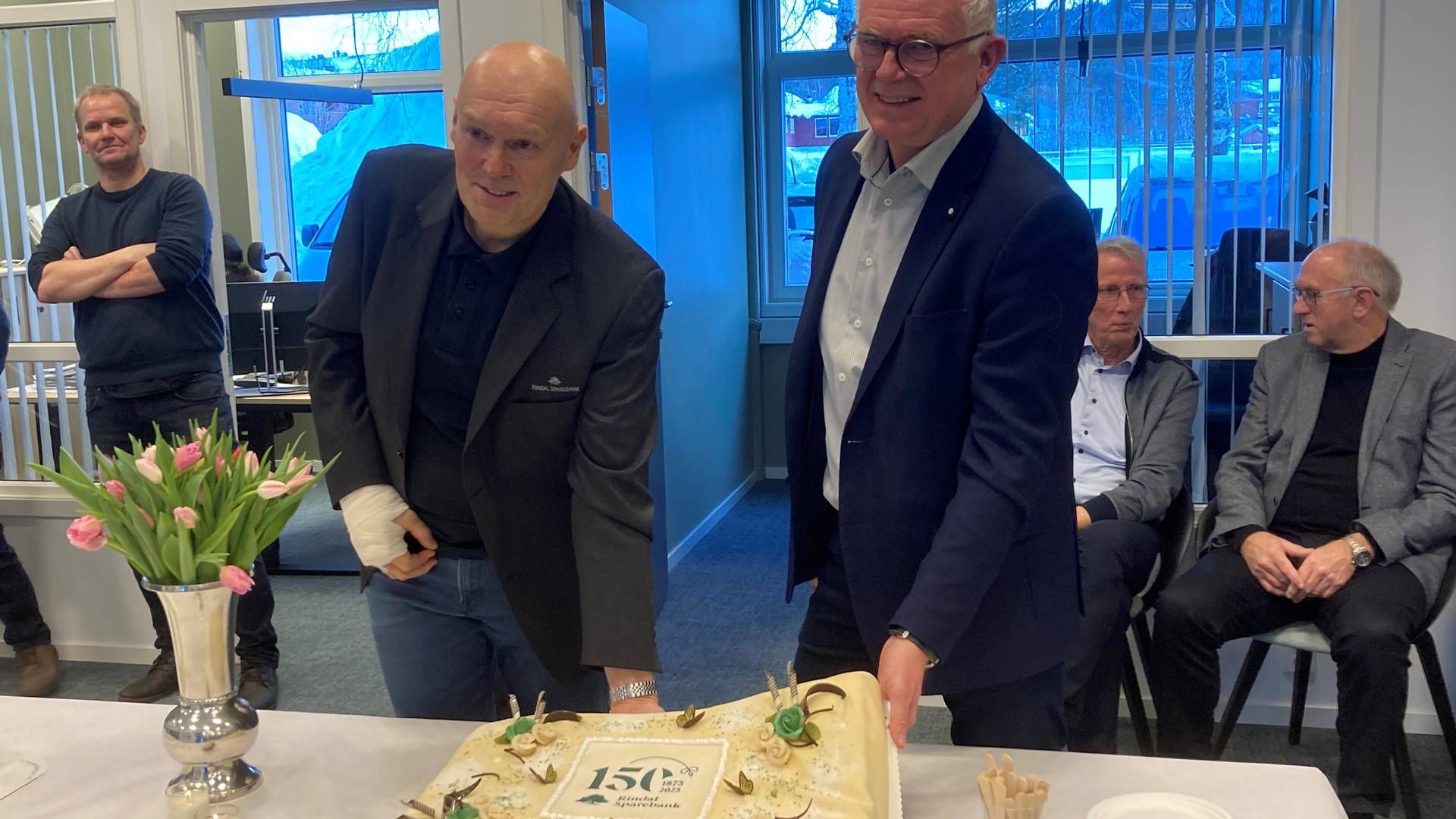 Banksjef Magne Bjørnstad og styreleder Per Kristian Øwre i Rindal sparebank feiret jubileet med kake 4. januar.