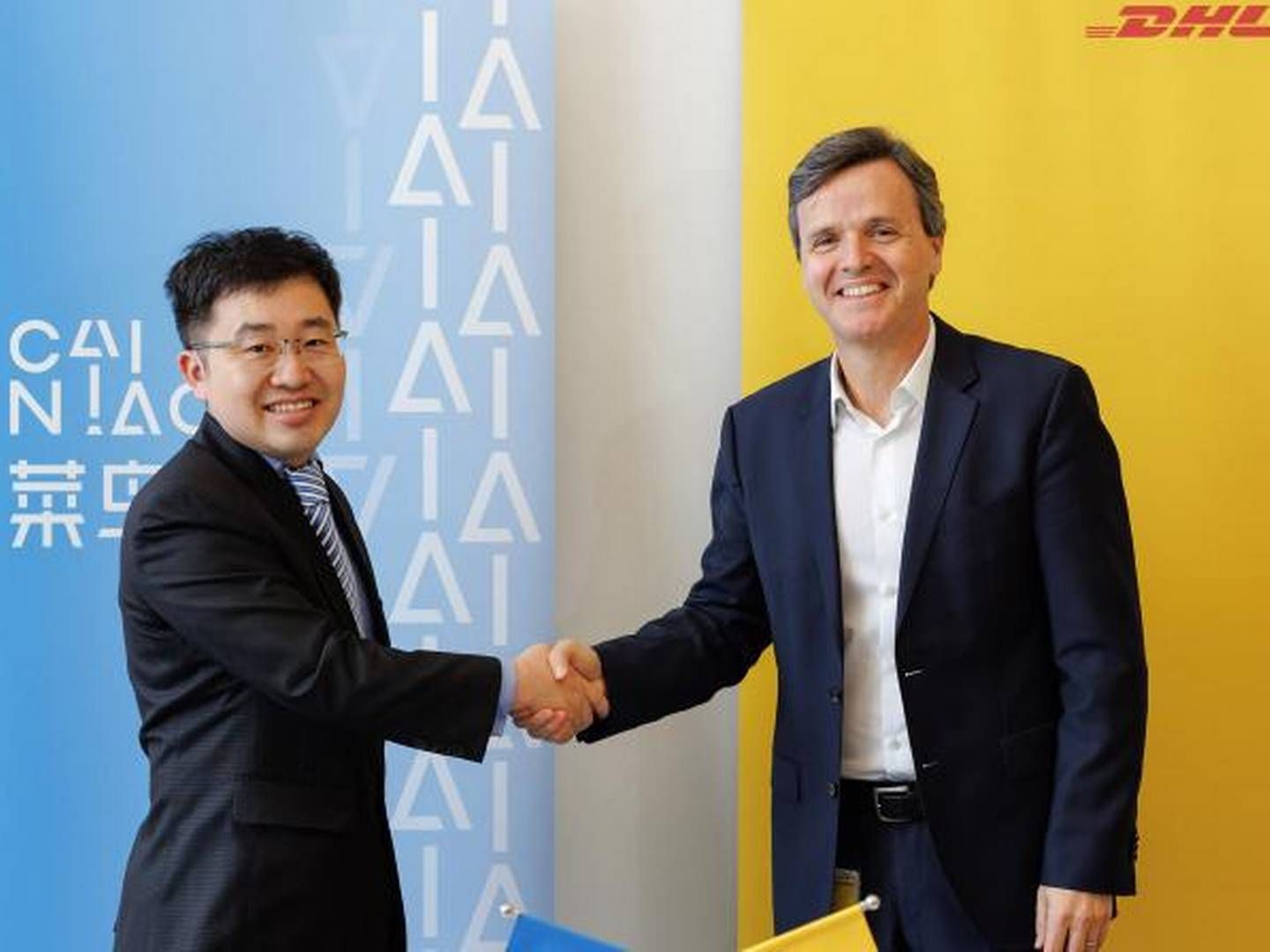 AloWilliam Xiong (tv), chef for Cainiao i Europa, og Pablo Ciano (th), chef for DHL Ecommerce Solutions, giver håndslag på aftale om fælles investering i det polske pakke- og distributionsmarked. | Foto: PR/DHL