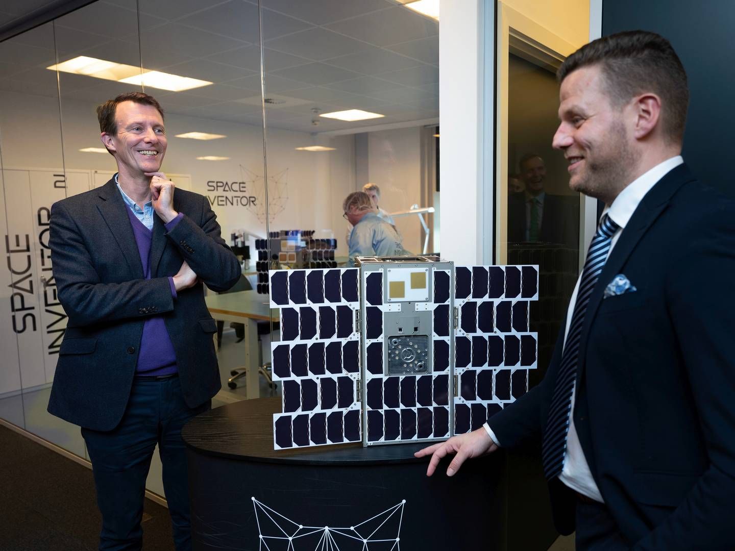 Karl Kaas (th), stifter af Space Inventor, fremviser satelitten til Prins Joachim. | Foto: Hr