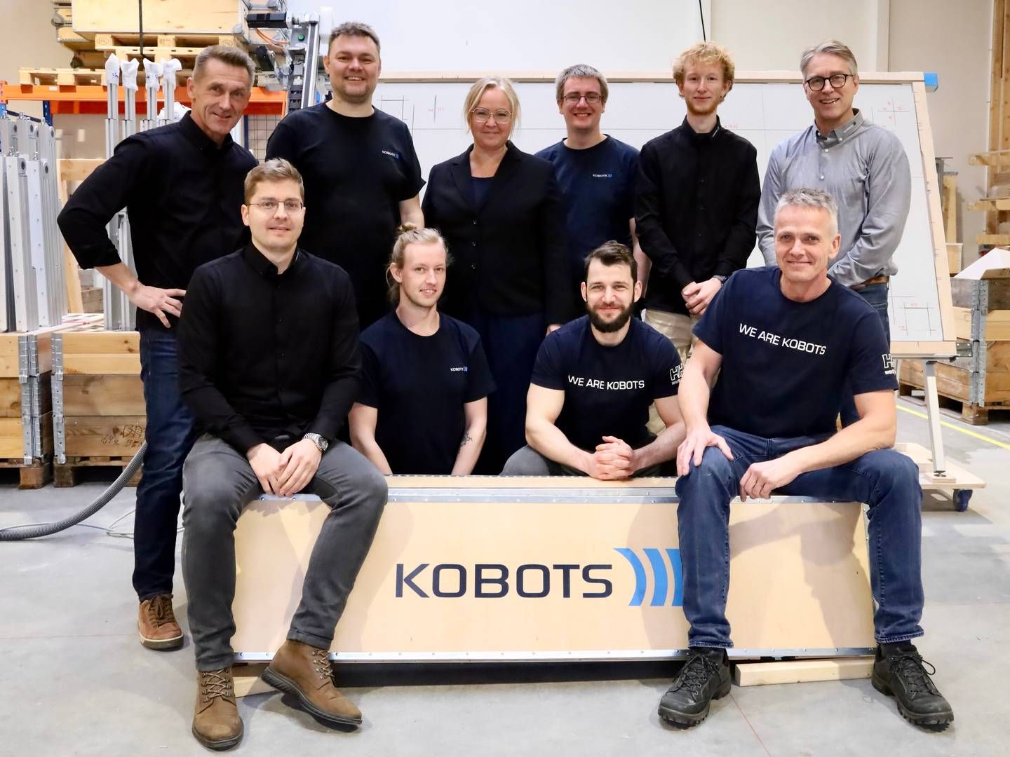 Seks ud af Kobots 10 nuværende medarbejdere samlet sammen med et hav af robotter, som var på vej til USA. | Foto: Kobots / Pr