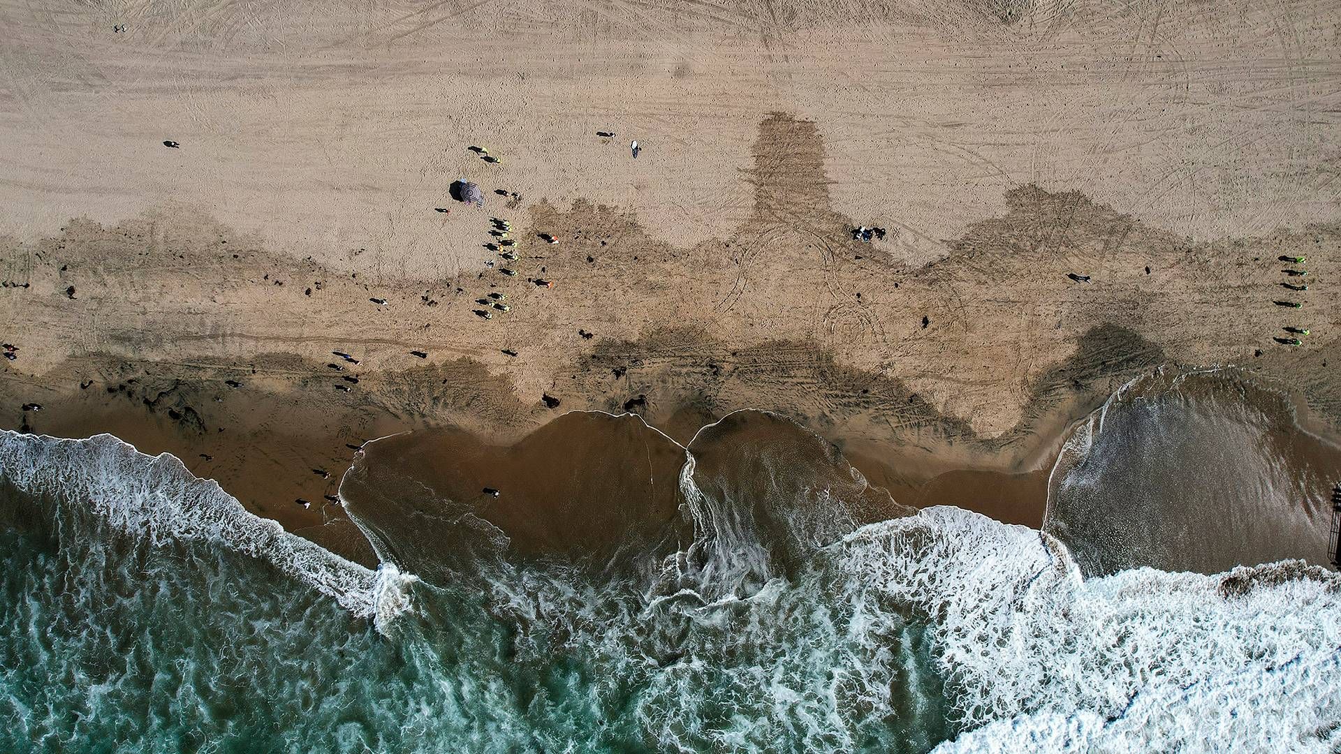 Olie fra udslippet ved Orange County i Californien blive renset fra en strand i Huntington Beach i oktober 2021. | Foto: Ringo H.w. Chiu/AP/Ritzau Scanpix