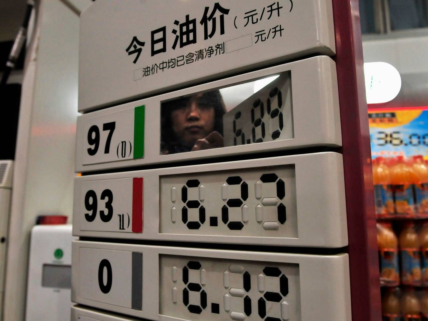 Archival picture of a gas station employee changing price signs in Nanjing, China, 2010. | Foto: Sean Yong/Reuters/Ritzau Scanpix
