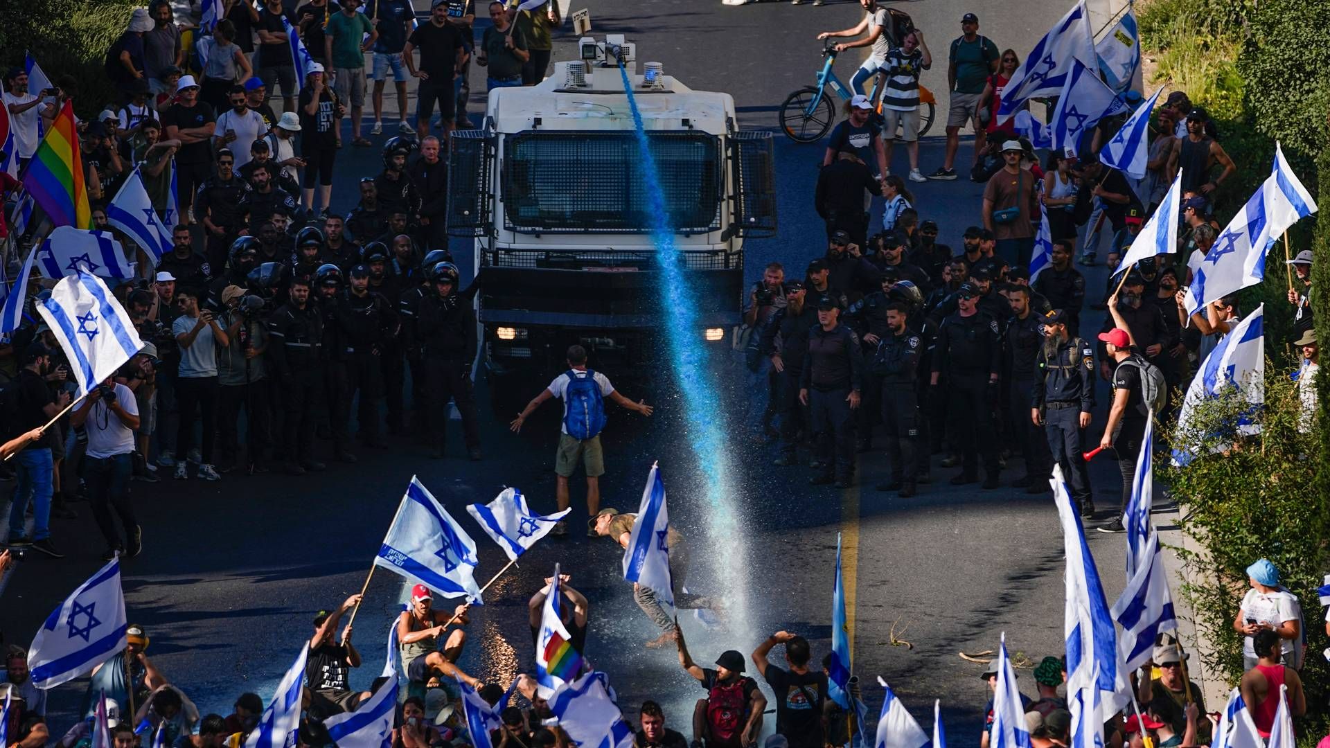 PROTESTER: Politiet brukte vannkanoner og tåregass for å forsøke å spre demonstrantene som blokkerte en motorvei i Jerusalem, og det er meldt at flere er skadd i opptøyene. | Foto: AP Photo/Ariel Schalit/NTB