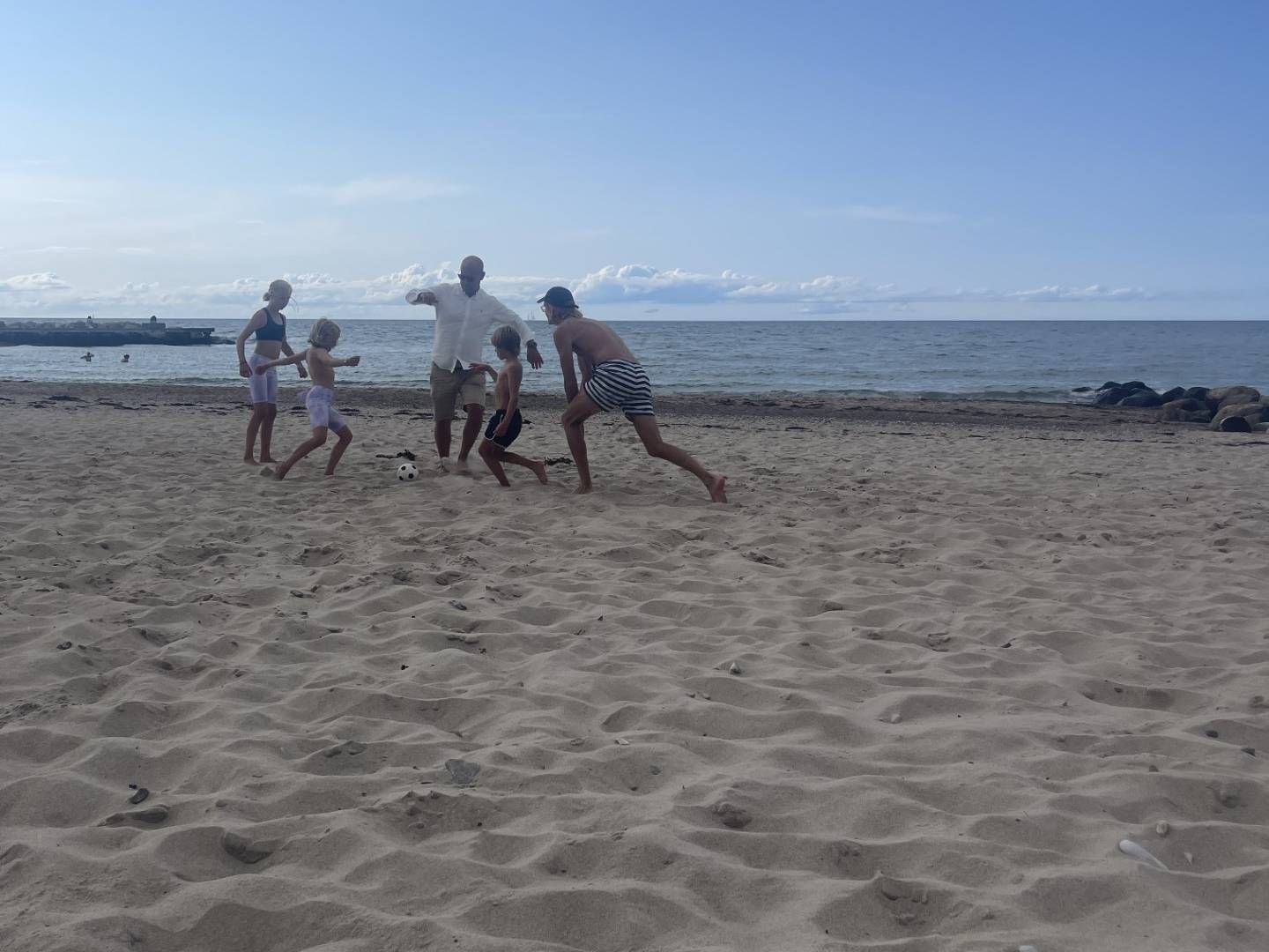 «DEJLIG Å VÆRE NORSK»: Her er Tom André Svenning-Gultvedt i ferd med å sparke en fotball, sammen med sine to døtre til venstre. Til høyre for Svenning-Gultvedt er sønnen hans og en venn. Bildet er tatt på stranden i Tisvildeleje (Helenekilde) i Danmark. | Foto: Privat