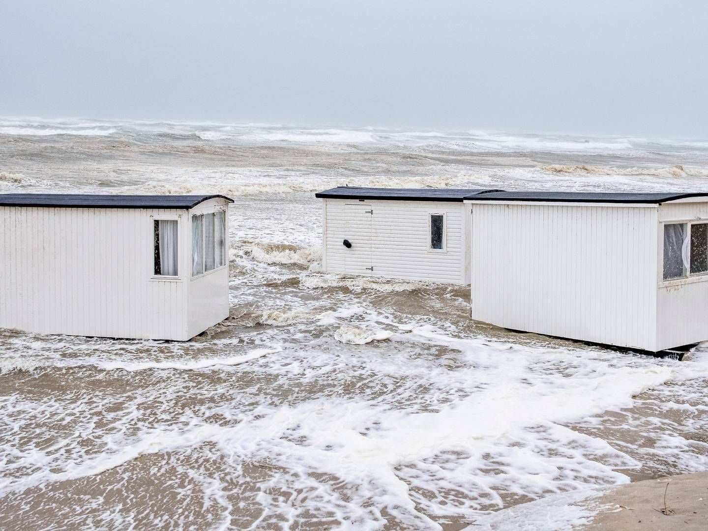 Badehuse på stranden i Løkken er blæst i havet som følge af den kraftige blæst. | Foto: Henning Bagger/Ritzau Scanpix