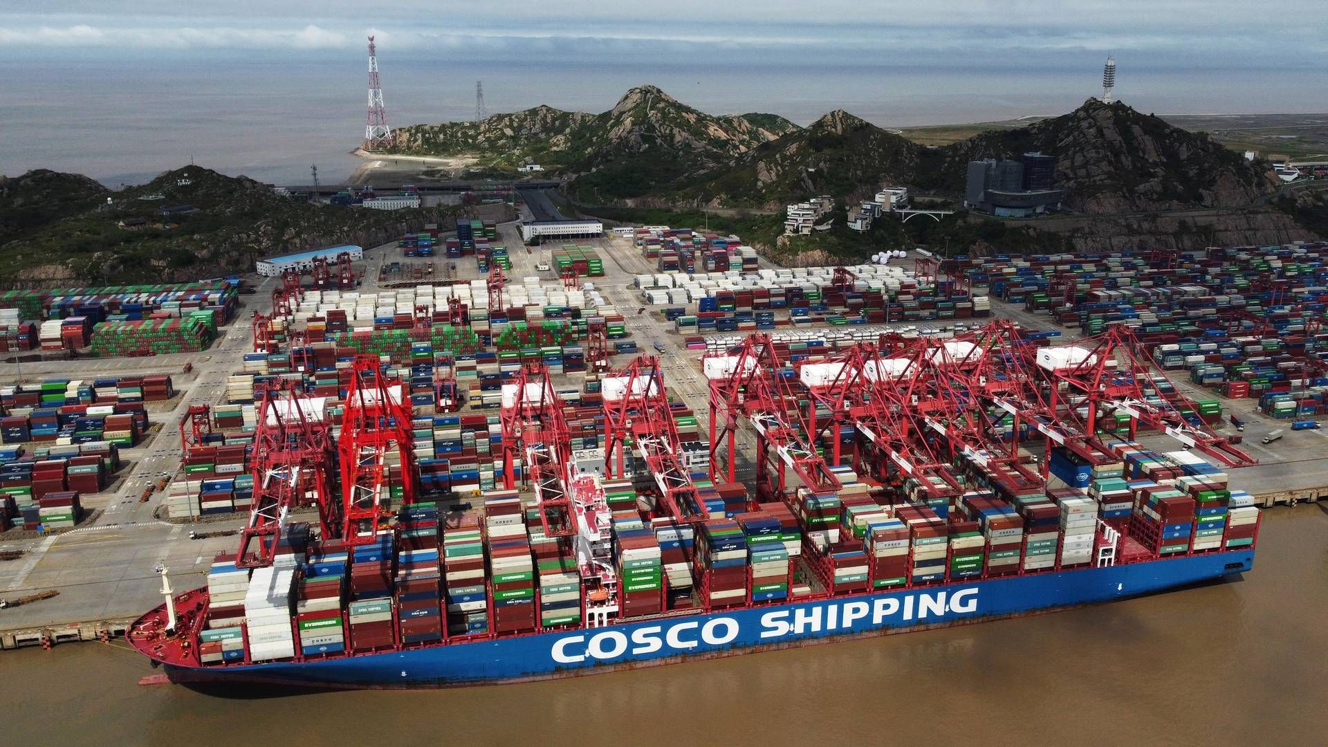 Et containerskib fra kinesiske Cosco Shipping Holdings i havnen i Shanghai. | Foto: Stringer/Reuters/Ritzau Scanpix