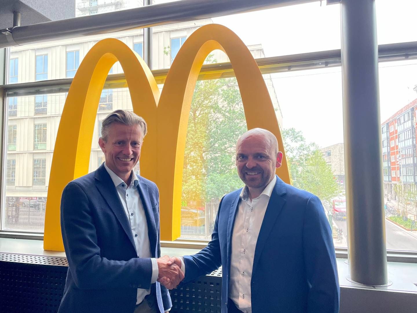 Mads Friis (adm. direktør hos McDonald’s i Danmark) og Mads Brøgger (direktør i Norlys' energiforretning) giver hånd på den nye aftale om lynladestandere. | Foto: Pr Norlys