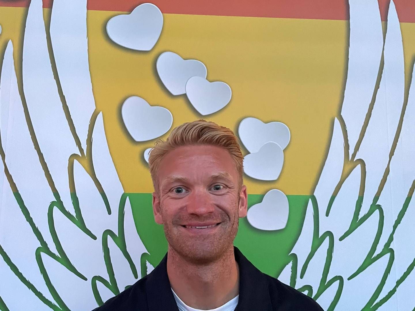 Christian Moselund Aaby, der er ansvarlig for public affairs i Nordea Danmark, svarer på spørgsmål om bankens engagement i Pride og ses her foran en Pride-udsmykket hæveautomat. | Foto: Privatfoto