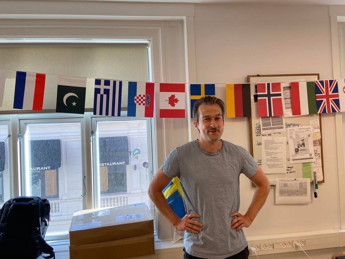 Søren Gleie, adm. direktør foran en stribe af flag, som repræsenterer medarbejdernes nationalitet. | Foto: Frederik Therkildsen