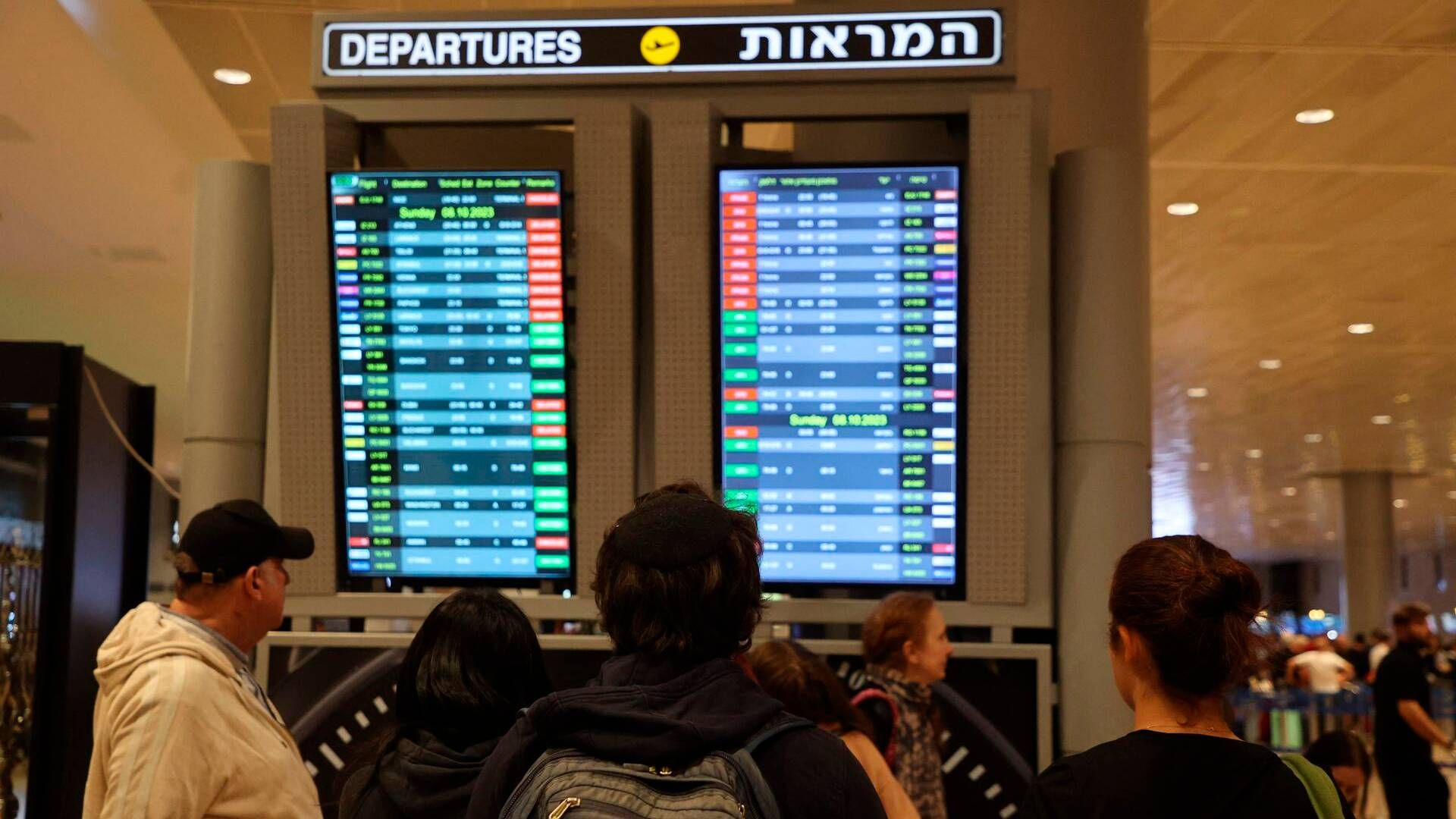 Passagerer kigger på en afgangstavle i Ben Gurion lufthavnen tæt ved Tel Aviv, hvor flere afgange er aflyst som følge af angreb. | Foto: Gil Cohen-Magen/AFP/Ritzau Scanpix