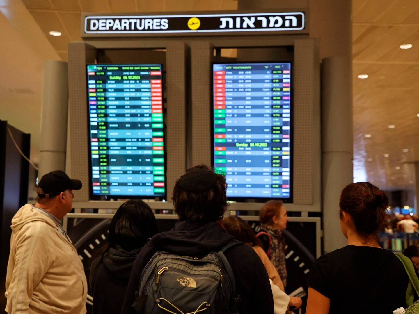 Passagerer kigger på en afgangstavle i Ben Gurion lufthavnen tæt ved Tel Aviv, hvor flere afgange er aflyst som følge af angreb. | Foto: Gil Cohen-Magen/AFP/Ritzau Scanpix