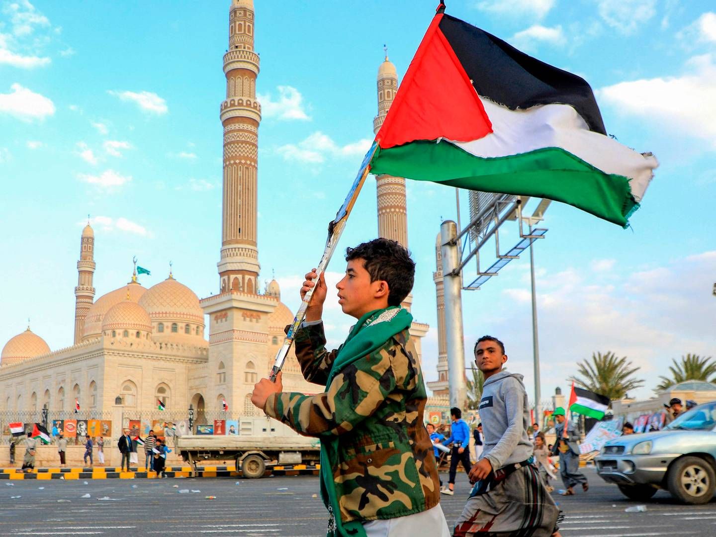 En yemenitisk ung mand vifter med et palæstinensisk flag under en march i solidaritet med Gazas befolkning i den Huthi-kontrollerede hovedstad Sanaa den 15. december. De Iran-støttede houthier, som kontrollerer store dele af Yemen, men ikke er internationalt anerkendte, siger, at de angriber skibsfarten for at presse Israel til at stoppe krigen i Gaza-striben. | Foto: Mohammed Huwais/AFP/Ritzau Scanpix