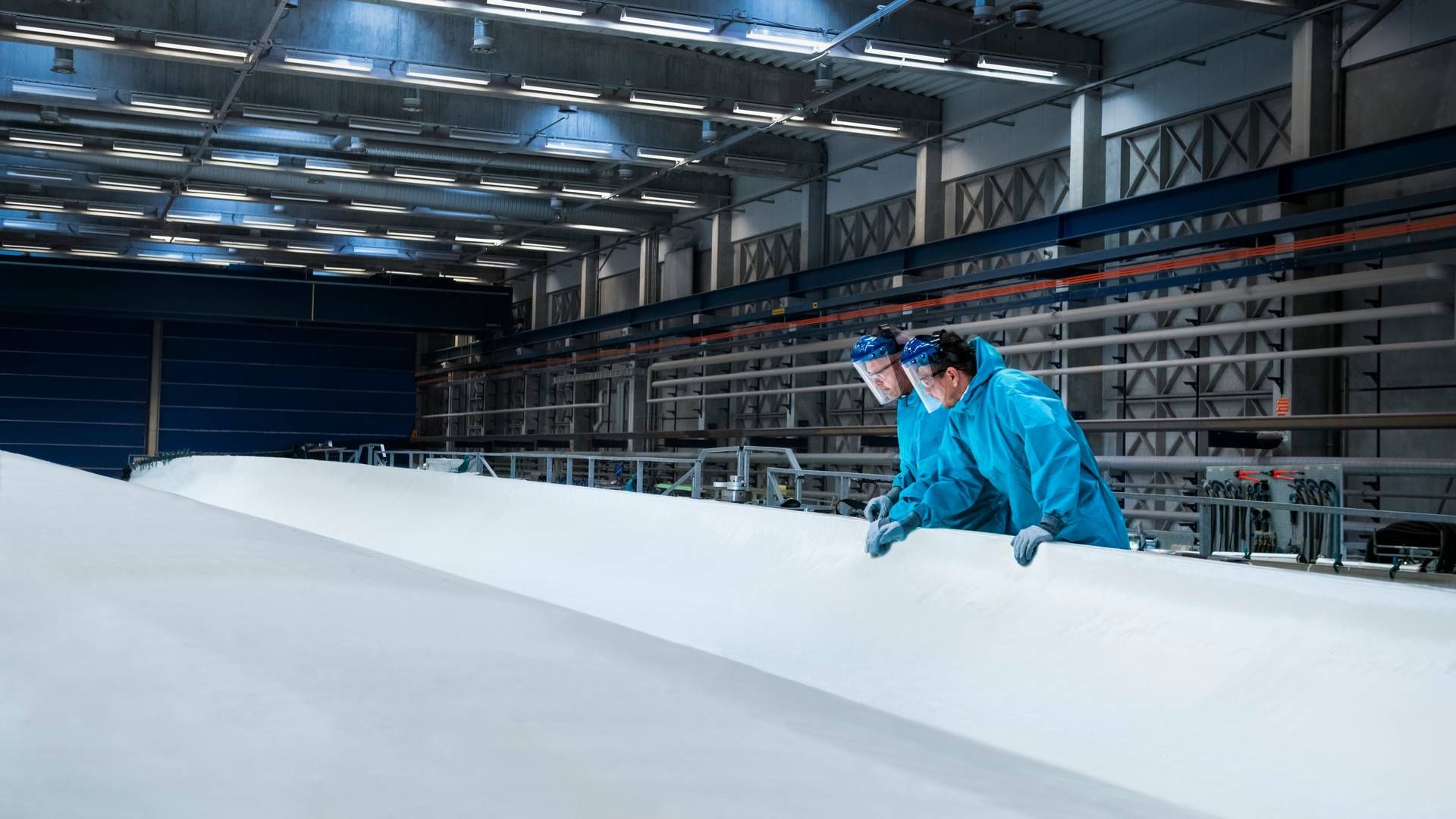 På billedet ses Vestas-ansatte inspicere en vinge til en havmølle på Vestas-fabrikken i Nakskov. | Foto: vestas