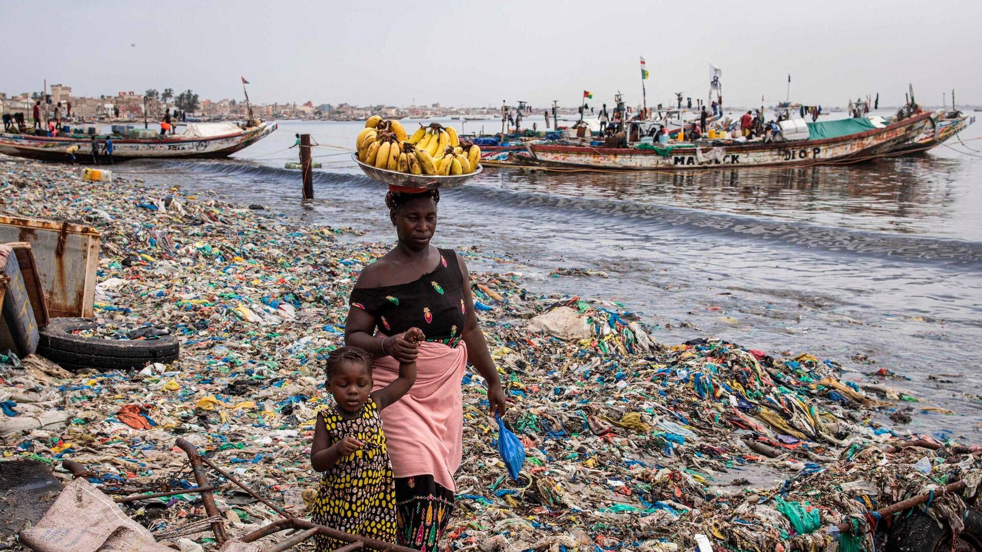 A mother and daughter walk along Hann Bay in Dakar, Senegal. Once an unspoilt bay, the area is now one of the most polluted in Dakar with a build-up of plastic and other materials penetrating meters deep into the sand. | Photo: John Wessels/AFP/Ritzau Scanpix