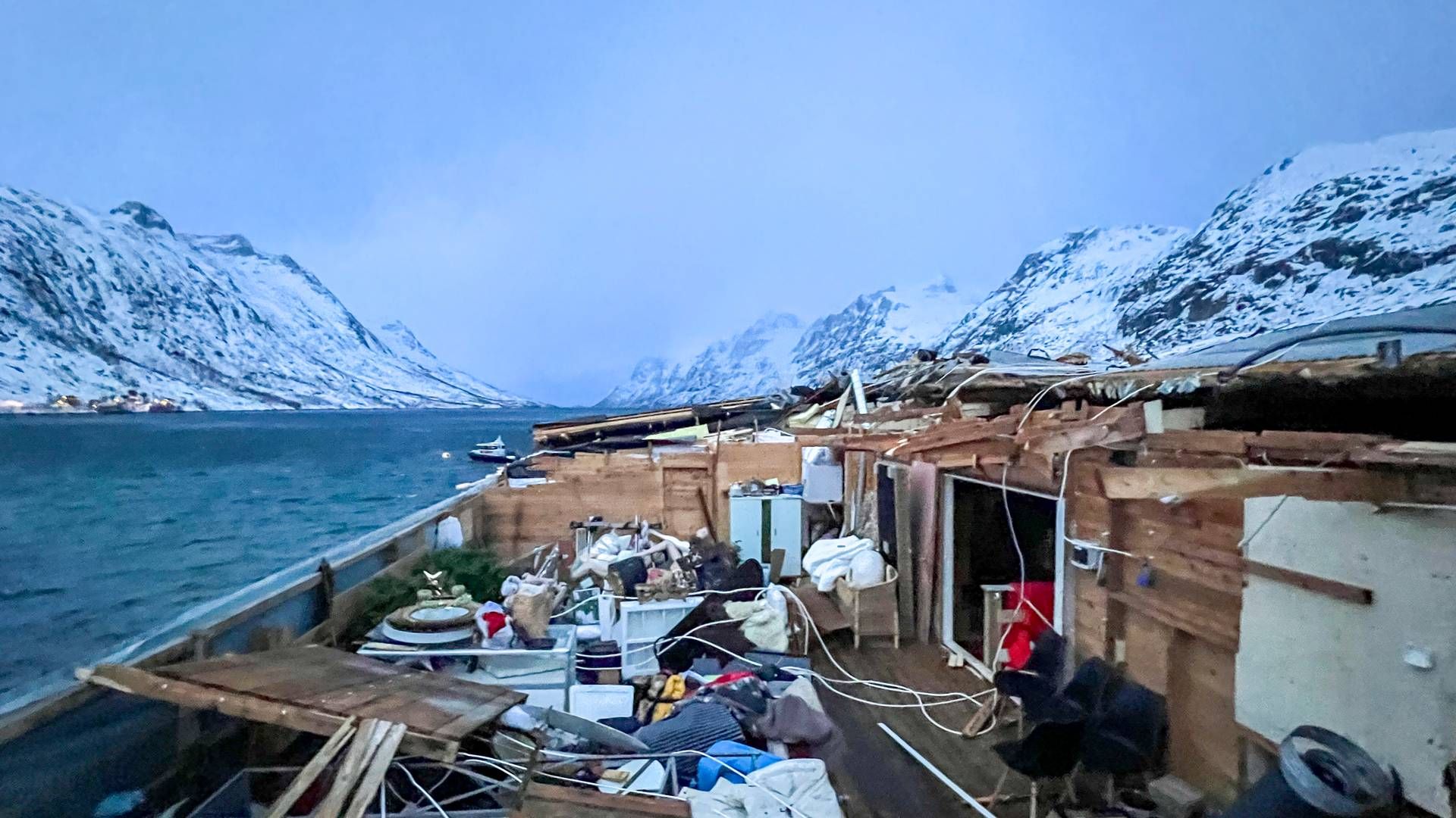 TATT AV VINDEN: De kraftige uværet i Nord-Norge har ført til en rekke takskader, blant annet på dette bygget på Kvaløya har blåst av. Bygningen huser blant annet kafeen Bryggejentene | Foto: Tromsø brann og redning / NTB