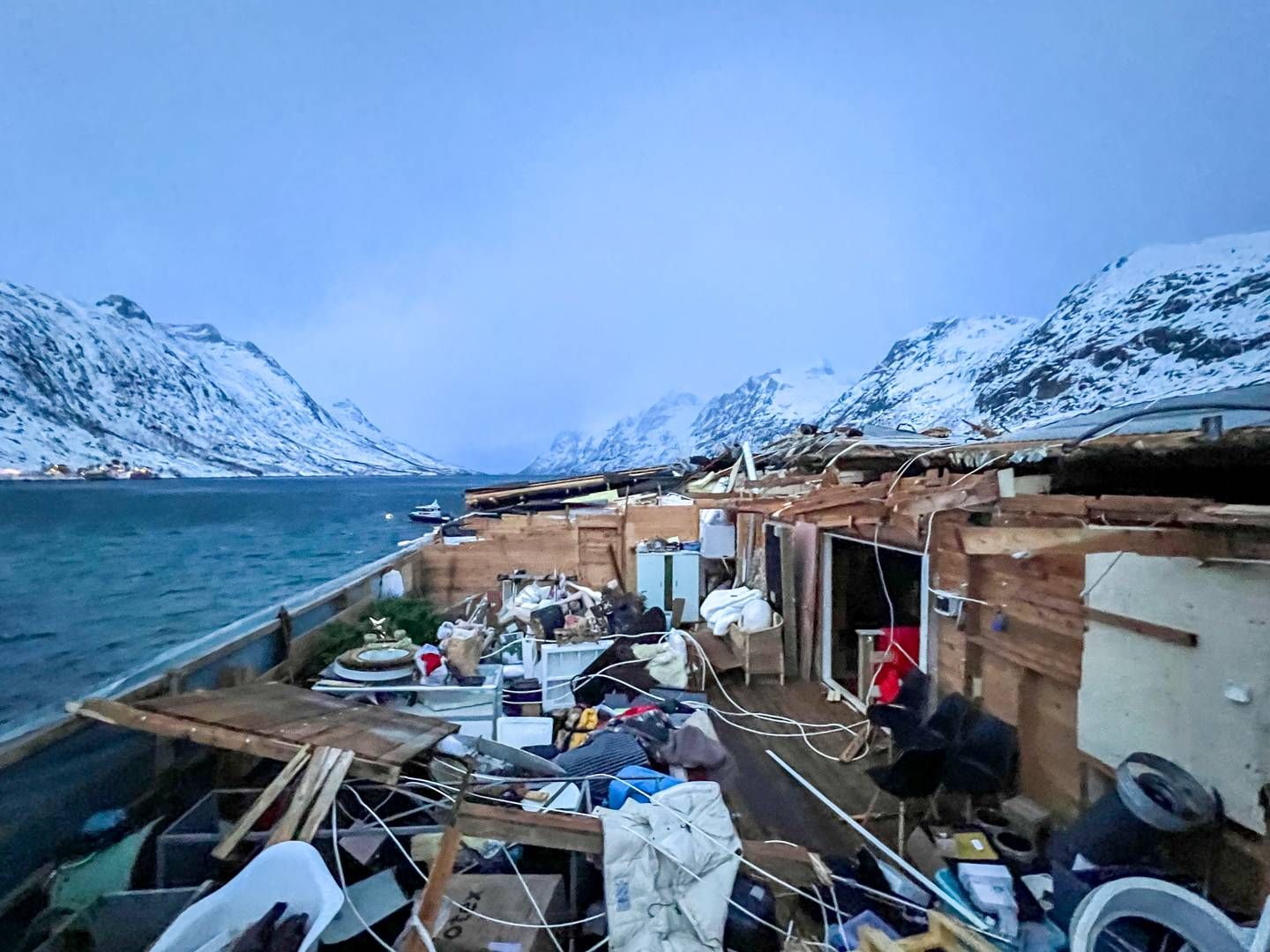 TATT AV VINDEN: De kraftige uværet i Nord-Norge har ført til en rekke takskader, blant annet på dette bygget på Kvaløya har blåst av. Bygningen huser blant annet kafeen Bryggejentene | Foto: Tromsø brann og redning / NTB