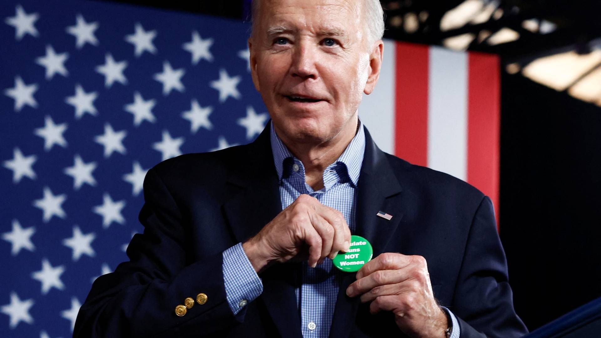 US President Joe Biden puts on a badge that reads "Regulate guns not women" during a campaign event at Pullman Yards in Atlanta in March. | Photo: Evelyn Hockstein