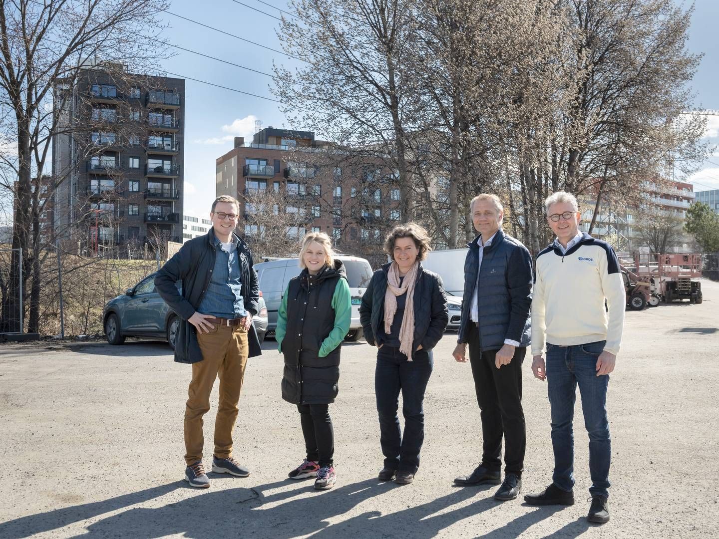 GRÅ ASFALT TIL GRØNN PARK: Her står aktørene i det som blir områdepark, fra grå asfalt til grønn park. Bak trærne skimtes boligprosjektet Ulven Park og kontorbyggene i Construction City. Fra venstre, Martin Berger (Skanska Eiendomsutvikling), Ina Lystad Jacobsen (Bane NOR Eiendom), Tanja Kleive Guettler (Bane NOR Eiendom), Christian Ekeli (KLP Eiendom), Anders Skauge (OBOS Nye Hjem). | Foto: Thomas Mellbye