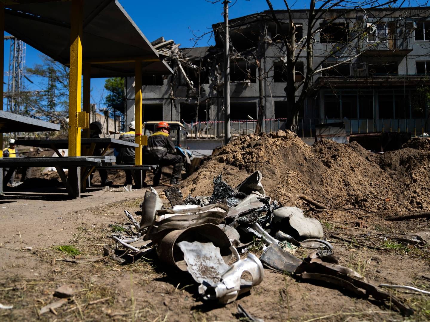 Rester etter en russisk missil samles ved siden av en skadet bygning på et DTEK-termisk kraftverk etter et russisk angrep i Ukraina, torsdag 2. mai 2024. Ukrainske energiarbeidere sliter med å reparere skadene fra stadig kraftigere luftangrep rettet mot å ødelegge Ukrainas energinett. | Foto: AP Photo/Francisco Seco