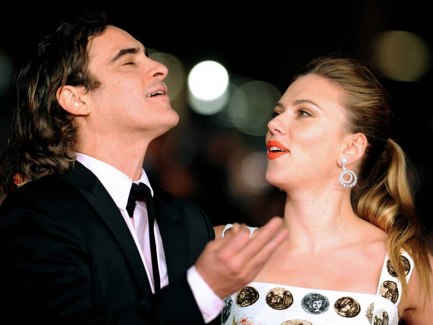 Skuespillerne Joaquin Phoenix og Scarlett Johansson spiller over for hinanden i filmen "Her", hvor en mand forelsker sig i sin chatbot. Her er de to fotograferet ved filmens premiere i 2013. Johansson mener, at en ny kunstig stemme fra OpenAI minder meget om hendes egen. Tirsdag beklager virksomheden over for Johansson. | Foto: Tiziana Fabi/Ritzau Scanpix