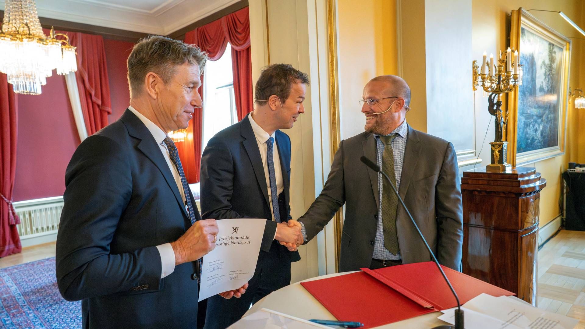 Norges energiminister Terje Aasland holder den nyligt underskrevne kontrakt om Sørlige Nordsjø II op, mens Peter van der Poel, administrerende direktør for Ingka, og Francois van Leeuw, administrerende direktør for Parkwind, giver hinanden hånden i Oslo, Norge, den 19. april 2024. | Photo: Heiko Junge/Reuters/Ritzau Scanpix