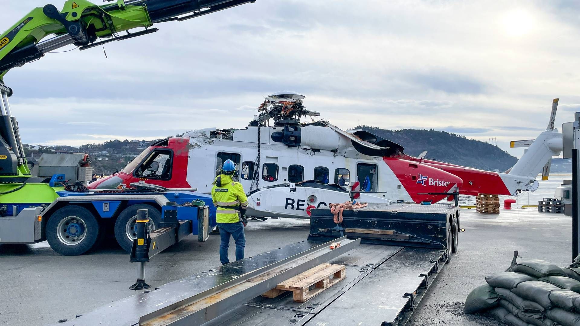 Helikopteret som havarerte kvelden onsdag 28. februar er hevet fra sjøen og blir heist på land ved Haakonsvern marinebase lørdag 2. mars. | Foto: Statens havarikommisjon / NTB