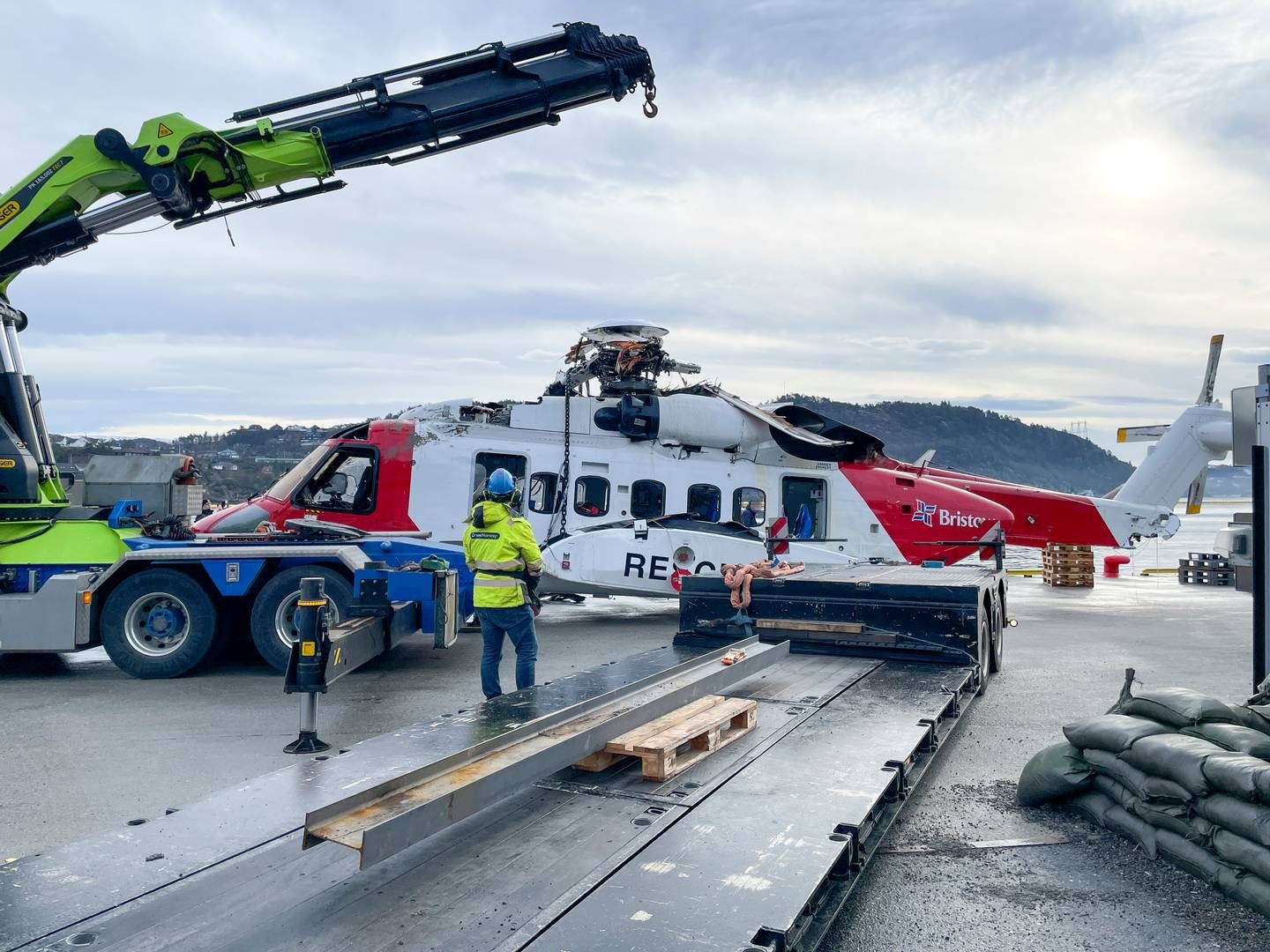 Helikopteret som havarerte kvelden onsdag 28. februar er hevet fra sjøen og blir heist på land ved Haakonsvern marinebase lørdag 2. mars. | Foto: Statens havarikommisjon / NTB