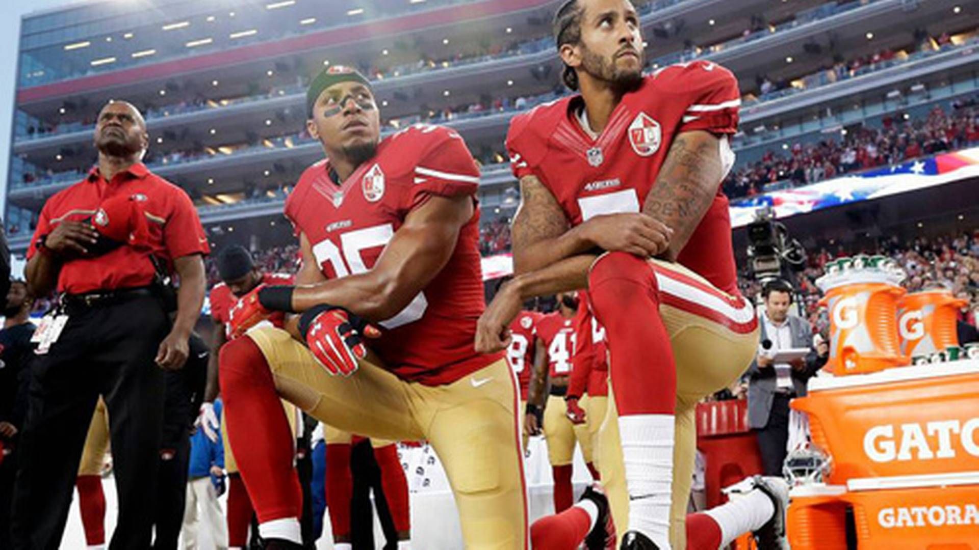 San Francisco 49ers' spillere Eric Reid og Colin Kaepernick (th.) knæler i protest under nationalhymnen før en NFL-kamp. | Foto: Marcio Jose Sanchez/AP