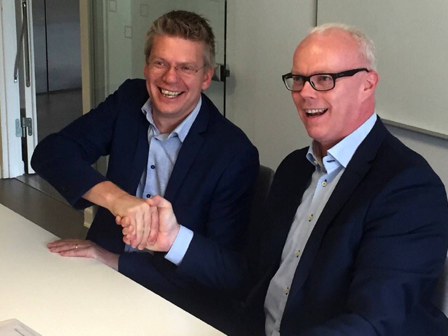 Martin Magelund Rasmussen, direktør i Region Hovedstaden (tv), og Allan Jepsen, adm. direktør i EG Silkeborg Data, giver hånd på aftalen, som sender en trecifret millionordre på nyt personalesystem i EG's retning. | Foto: PR/EG Silkeborg Data