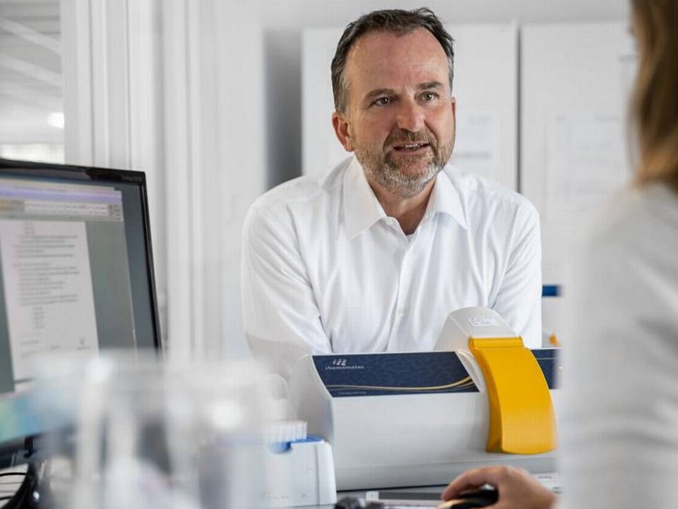 Michael Eising, adm. direktør i Chemometec, ved siden af et eksemplar af selskabets celletæller NC-200 (maskinen i gul, blå og grå). | Foto: Chemometec