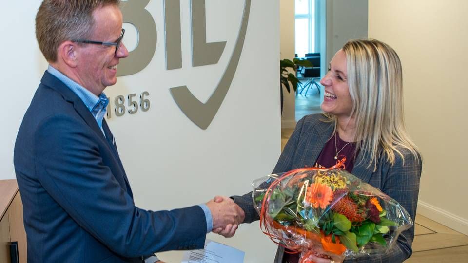 Certifikat nr. 10.000: Silvia Sølvsteen får overrakt blomster og certifikat af Claus Henriksen fra Finanssektorens Uddannelsescenter. | Foto: PR