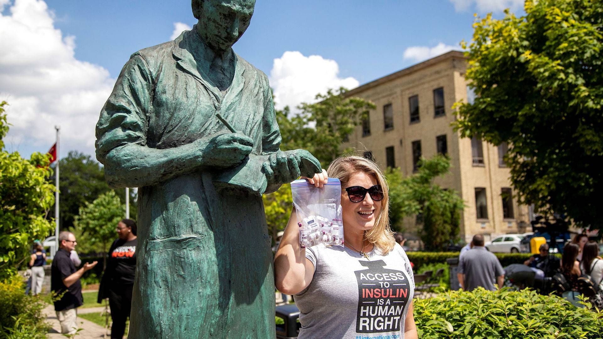 En kvinde, som demonstrerer mod høje insulinpriser, får her taget et billede med en statue af Frederick Banting, manden som opdagede insulin i 1921, i byen London i Canada. | Foto: Carlos Osorio / Reuters / Ritzau Scanpix