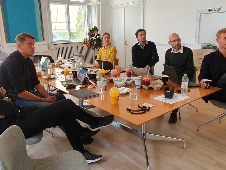 Max Sejbæk, længst til højre, Mikkel Aude nummer tre fra højre. Til venstre i blå polo er Henrik Kim Christensen og endelig Peter Skjødt, der læser sig ind over bordet. De øvrige er managerer i Proactive. | Foto: Jakob Skouboe