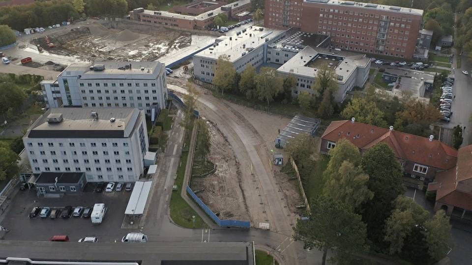 Etape 1 opføres på byggepladsen bag Lersø-komplekset (bagerst til venstre). I næste etape nedrives den eksisterende psykiatri (de to hvide bygninger forrest til venstre), så etape 2 af nybyggeriet kan opføres. | Foto: Martin Budig.