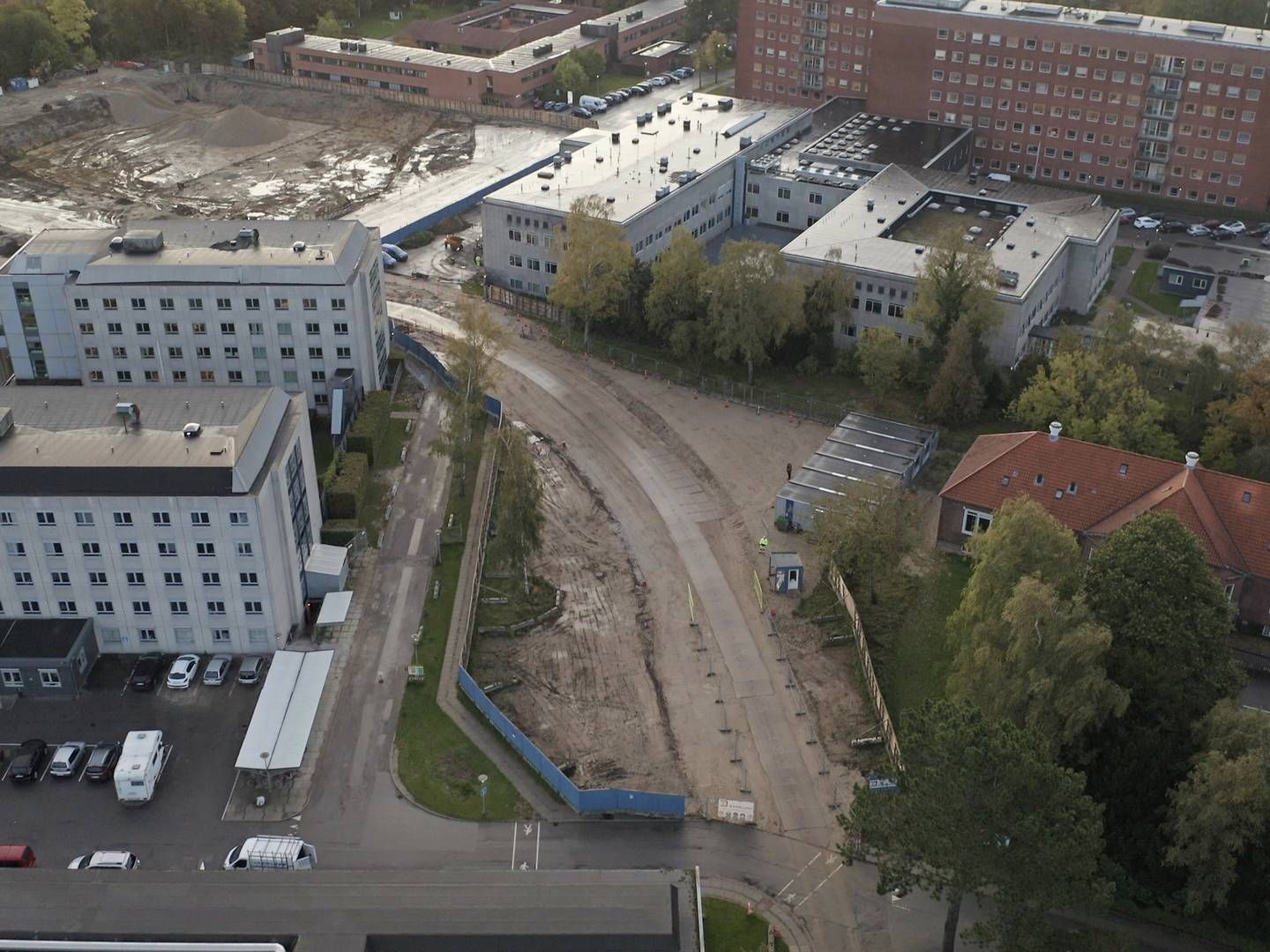 Etape 1 opføres på byggepladsen bag Lersø-komplekset (bagerst til venstre). I næste etape nedrives den eksisterende psykiatri (de to hvide bygninger forrest til venstre), så etape 2 af nybyggeriet kan opføres. | Foto: Martin Budig.