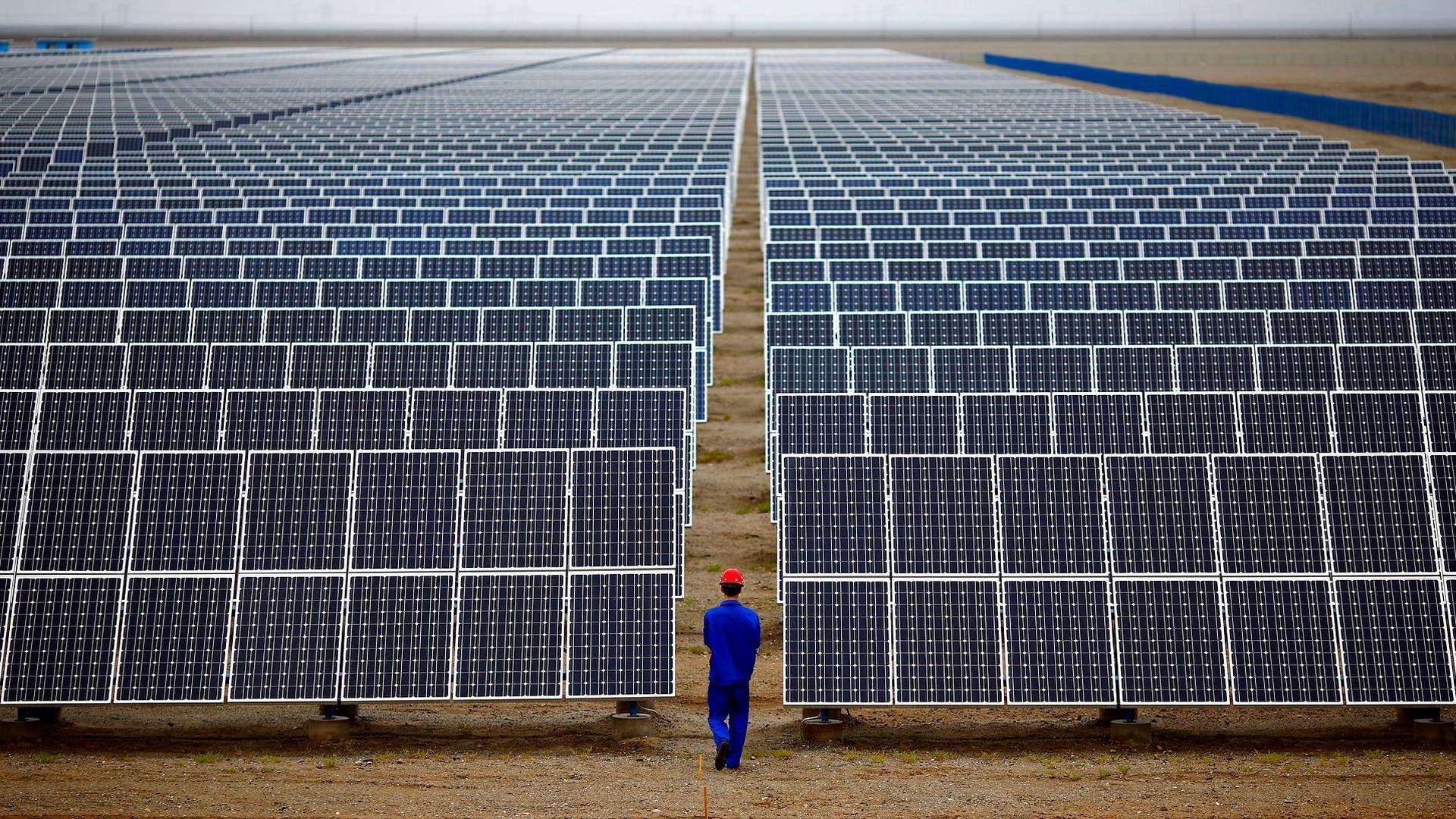 This file photo shows a worker inspecting solar farm in 2013. | Photo: Carlos Barria/Reuters/Ritzau Scanpix