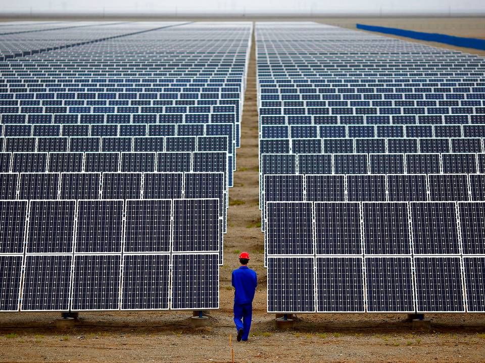 This file photo shows a worker inspecting solar farm in 2013. | Photo: Carlos Barria/Reuters/Ritzau Scanpix