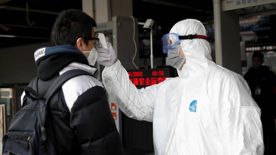 En mand får taget sin temperatur, som en indikation på smitte med coronavirus, inden han lukkes ind i på en metro i Beijing. | Foto: CARLOS GARCIA RAWLINS/REUTERS / X03739