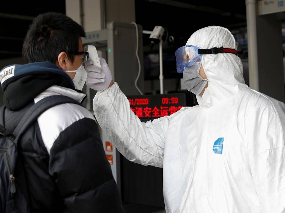 En mand får taget sin temperatur, som en indikation på smitte med coronavirus, inden han lukkes ind i på en metro i Beijing. | Foto: CARLOS GARCIA RAWLINS/REUTERS / X03739