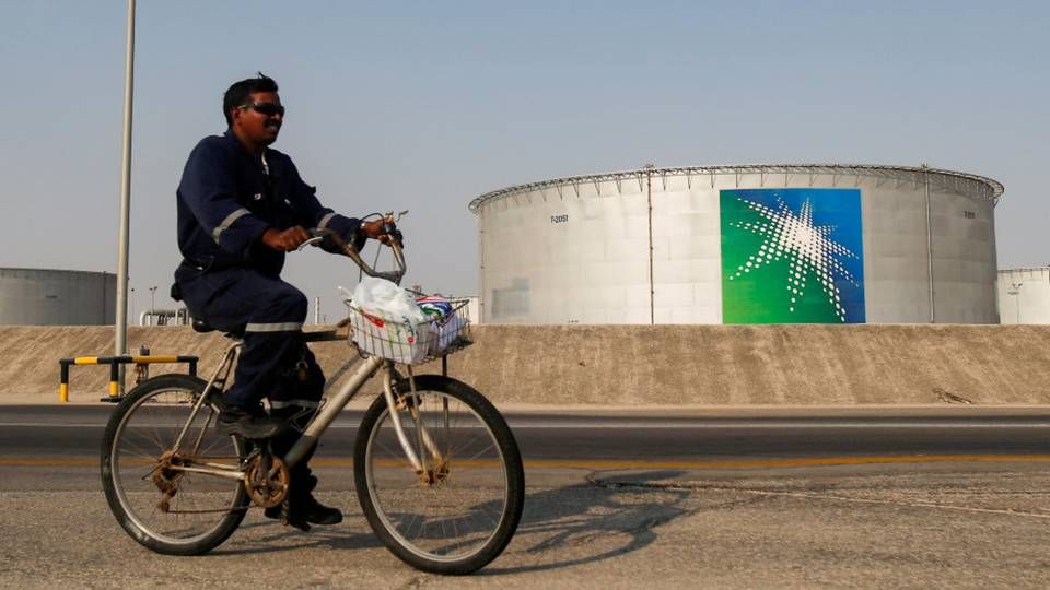 En medarbejder kører forbi en olietank tilhørende verdens største olieproducent, saudiarabiske Aramco. | Foto: Maxim Shemetov/Reuters/Ritzau Scanpix.