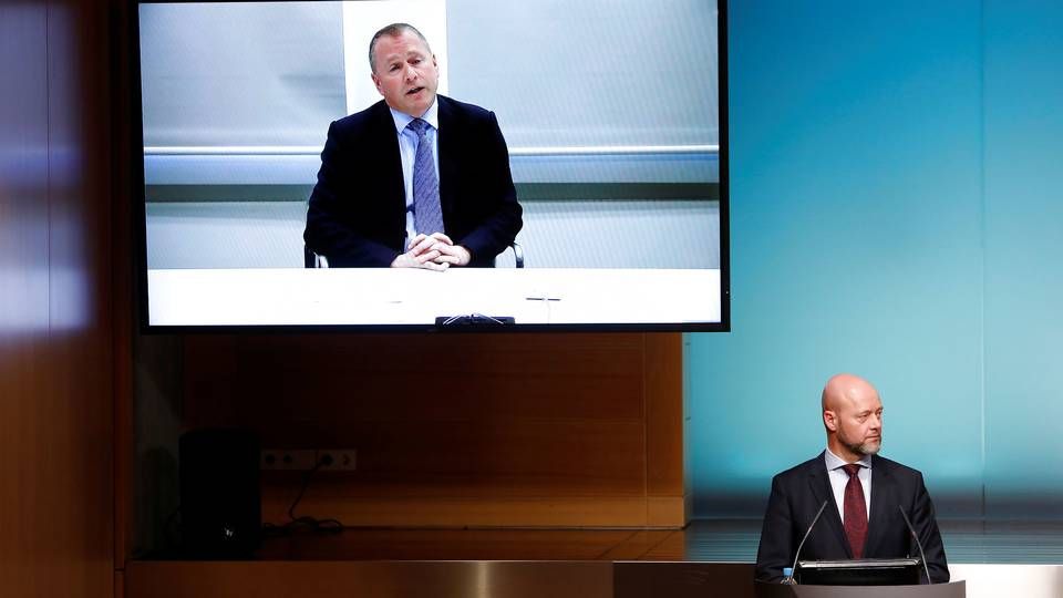 Incoming CEO of Norway's sovereign wealth fund Nicolai Tangen (large screen) paid travel costs for the fund's current chief, Yngve Slyngstad (podium). | Photo: Ntb Scanpix/Reuters/Ritzau Scanpix/via REUTERS / X02351
