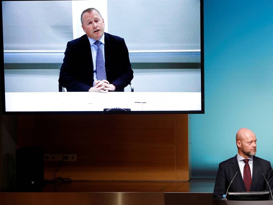 Incoming CEO of Norway's sovereign wealth fund Nicolai Tangen (large screen) paid travel costs for the fund's current chief, Yngve Slyngstad (podium). | Photo: Ntb Scanpix/Reuters/Ritzau Scanpix/via REUTERS / X02351