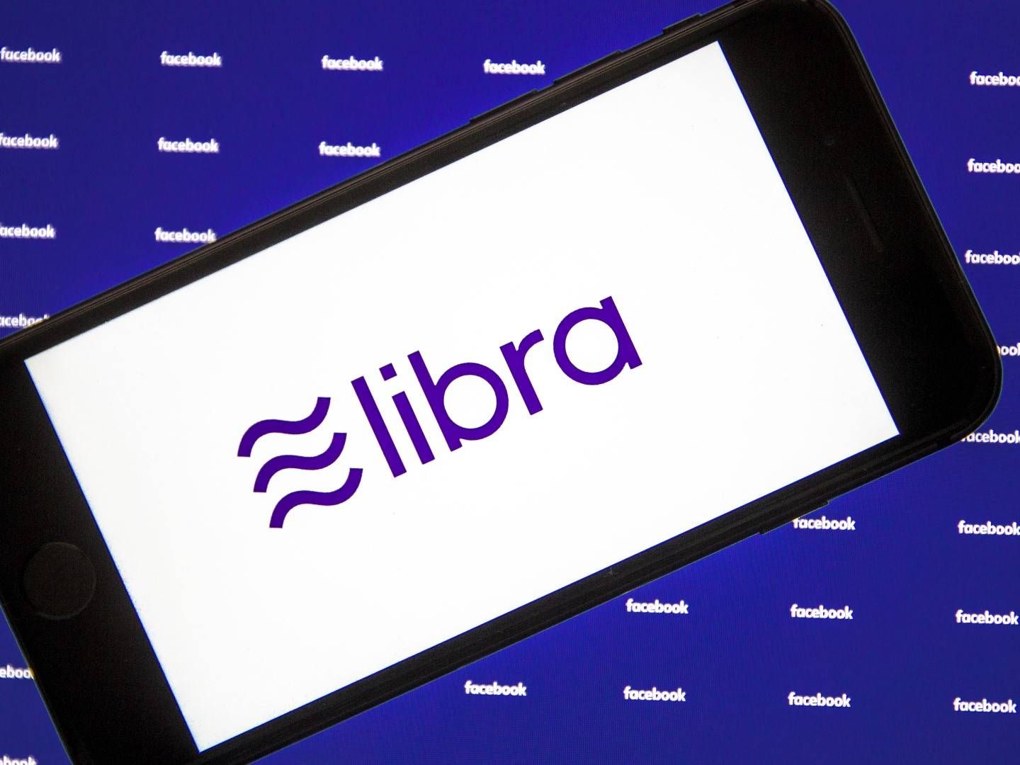 Illustration eines Smartphones mit dem Libra-Logo auf dem Display. | Foto: Picture-Alliance / AA
