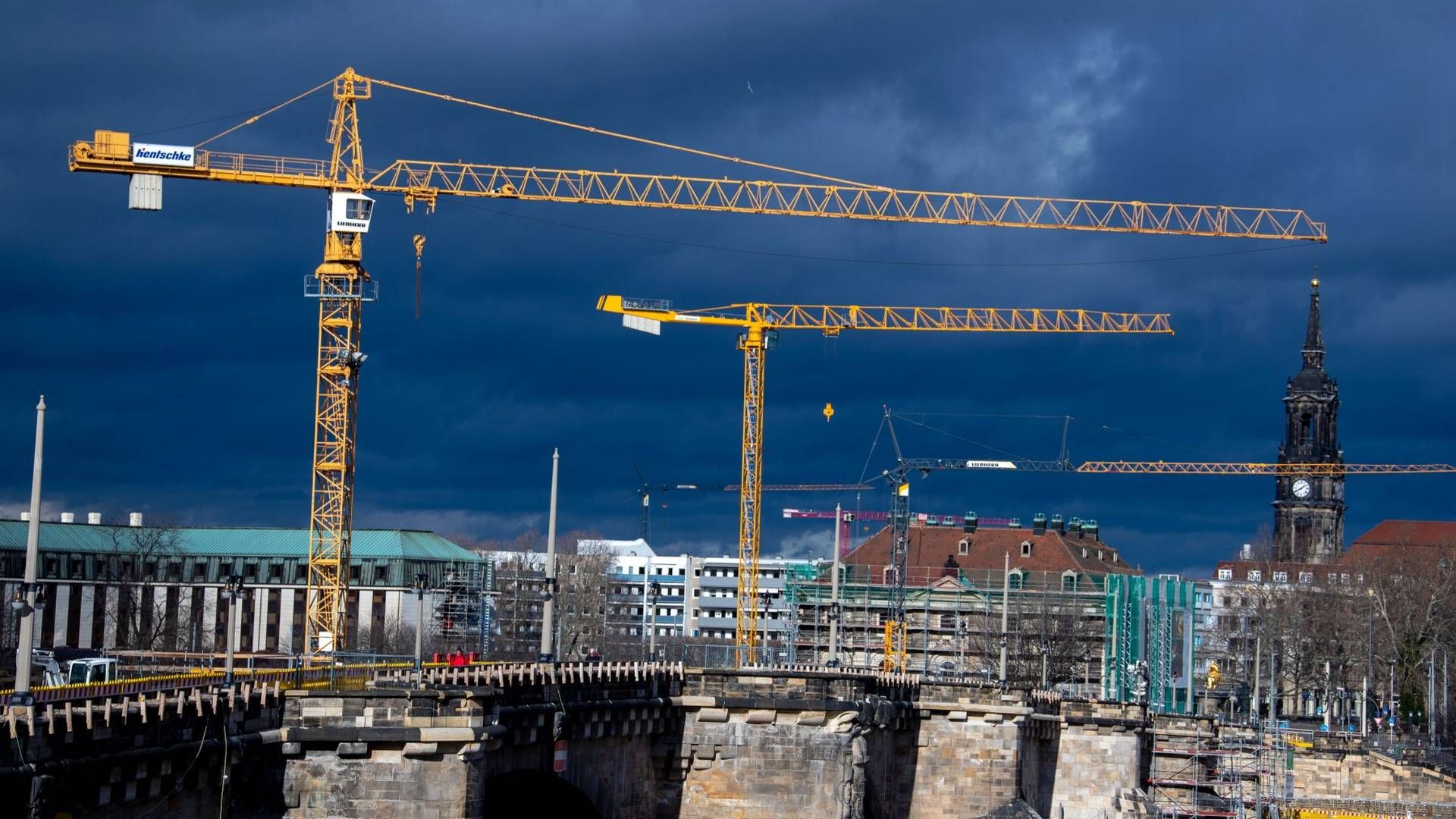 Baukräne vor düsterem Himmel in Dresden. | Foto: picture alliance/Jens Büttner/dpa-Zentralbild/ZB