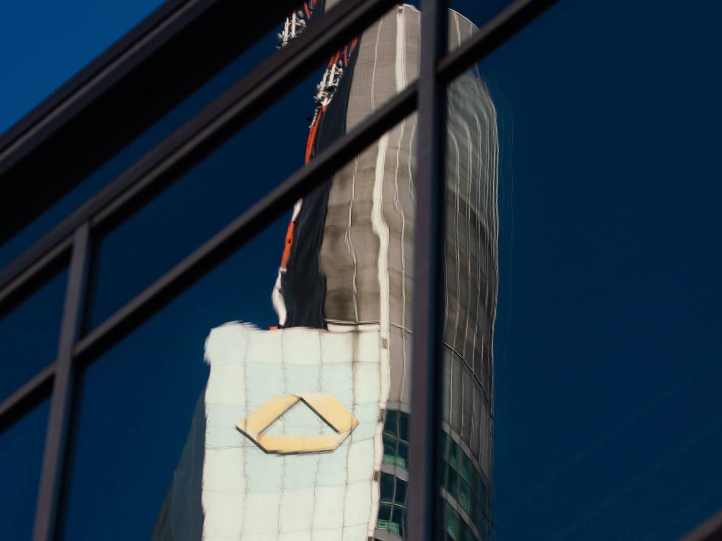 Das Logo der Commerzbank spiegelt sich in einem anderen Hochhaus. | Foto: picture alliance/Frank Rumpenhorst/dpa