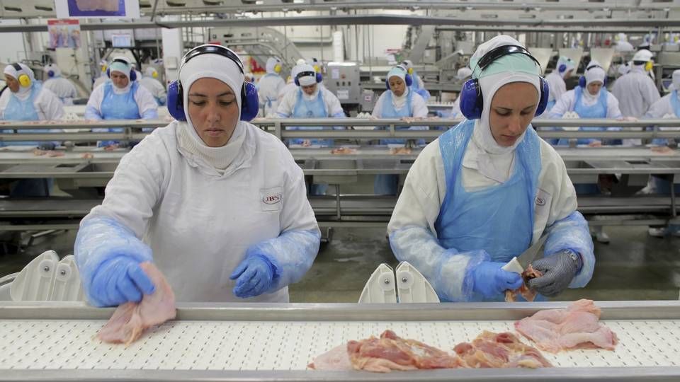 Arbeidere forbereder kyllingkjøtt ved JBS' fabrikk i Lapa, Brasil. Nordea Asset Management har kastet selskapet ut av sine fond etter gjentatte avsløringer som knytter selskapet til avskoging av Amazonas. | Foto: NTB scanpix/AP Photo/Eraldo Peres