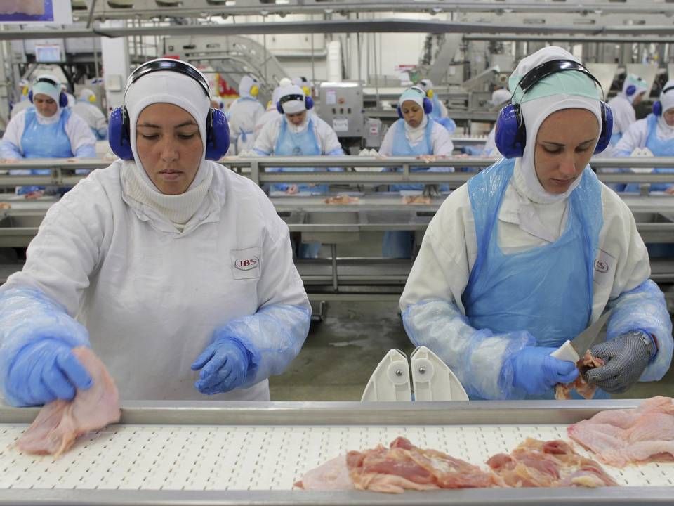 Arbeidere forbereder kyllingkjøtt ved JBS' fabrikk i Lapa, Brasil. Nordea Asset Management har kastet selskapet ut av sine fond etter gjentatte avsløringer som knytter selskapet til avskoging av Amazonas. | Foto: NTB scanpix/AP Photo/Eraldo Peres