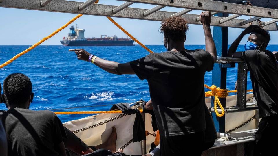 Migranter ombord på et civilt skib ser over mod Maersk Etienne, der har ligget for anker ud for Maltas kyst i en måned. | Foto: THOMAS LOHNES/AFP / AFP